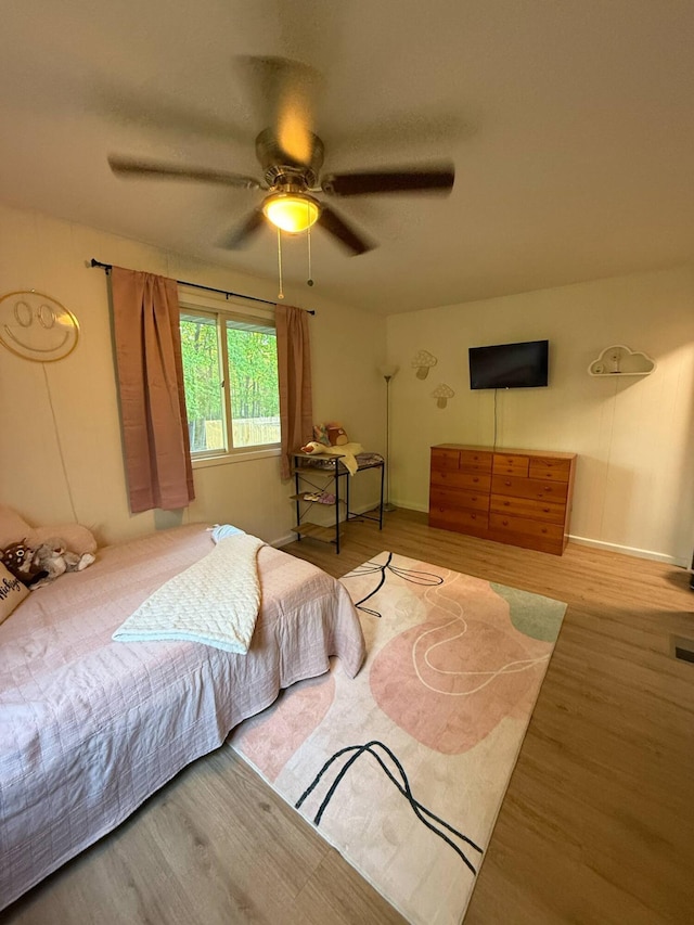 116 1st St, Hubbard Lake, MI 49747 - bedroom featuring wood finished floors, ceiling fan, and baseboards