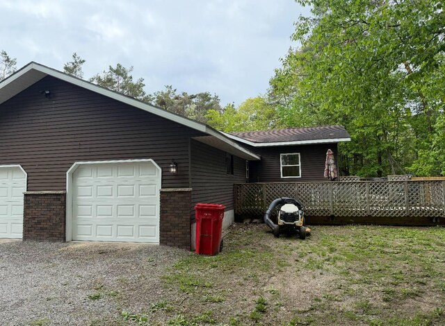 116 1st St, Hubbard Lake, MI 49747 - view of side of property featuring an attached garage