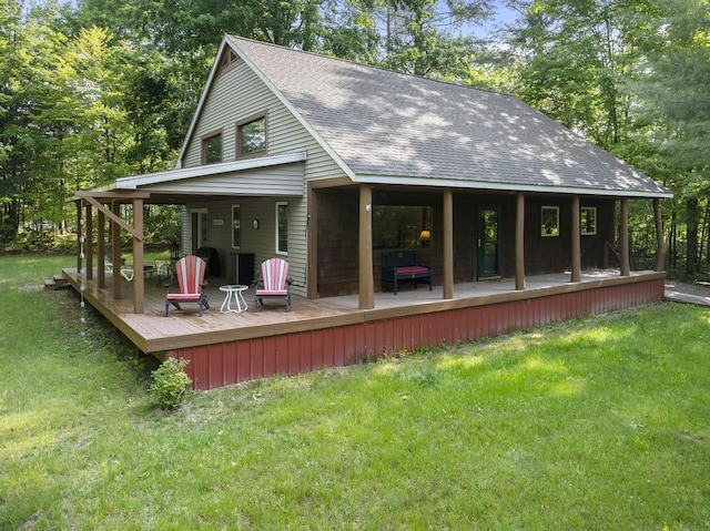 2715 Indian Rd, Brutus, MI 49716 - rear view of house with roof with shingles, a yard, a wooden deck, and view of scattered trees