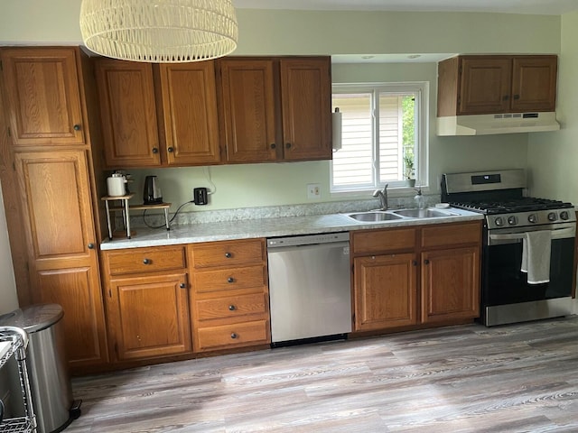 117 Swift Deer Trl, Prudenville, MI 48651 - kitchen featuring stainless steel appliances, under cabinet range hood, a sink, and brown cabinetry