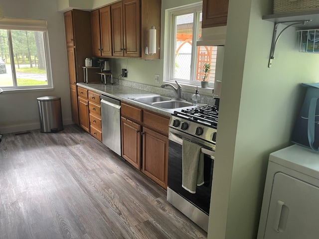 117 Swift Deer Trl, Prudenville, MI 48651 - kitchen with appliances with stainless steel finishes, a sink, brown cabinetry, and wall chimney range hood