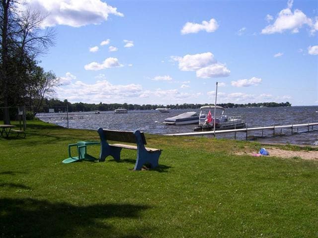 117 Swift Deer Trl, Prudenville, MI 48651 - view of community with a lawn, a water view, a boat dock, and uncovered parking