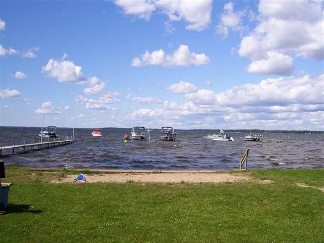 117 Swift Deer Trl, Prudenville, MI 48651 - dock with a water view and a lawn