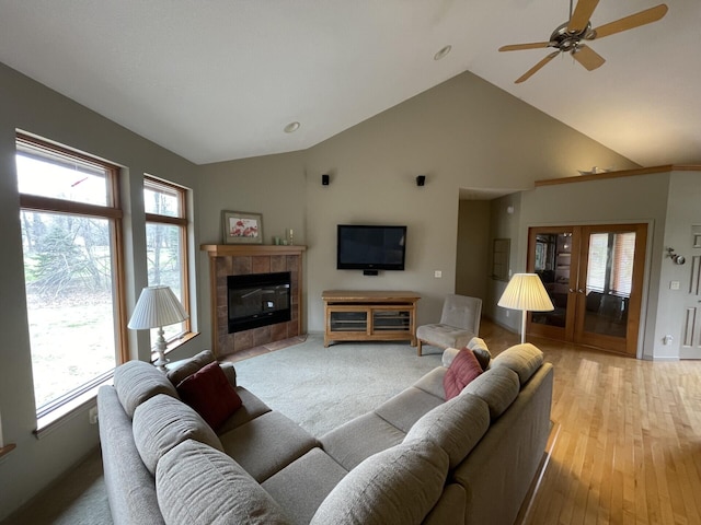 164 Invitational Dr, Gaylord, MI 49735 - living area with lofted ceiling, a ceiling fan, plenty of natural light, a tiled fireplace, and light wood-type flooring