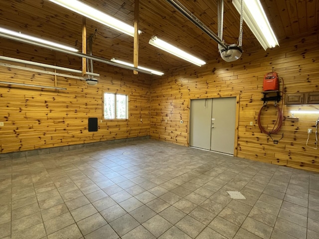 164 Invitational Dr, Gaylord, MI 49735 - garage featuring a garage door opener and wooden walls