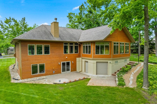 164 Invitational Dr, Gaylord, MI 49735 - back of house featuring a chimney, a yard, roof with shingles, a patio area, and a garage