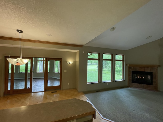 164 Invitational Dr, Gaylord, MI 49735 - unfurnished living room featuring wood finished floors, a fireplace, a textured ceiling, and french doors