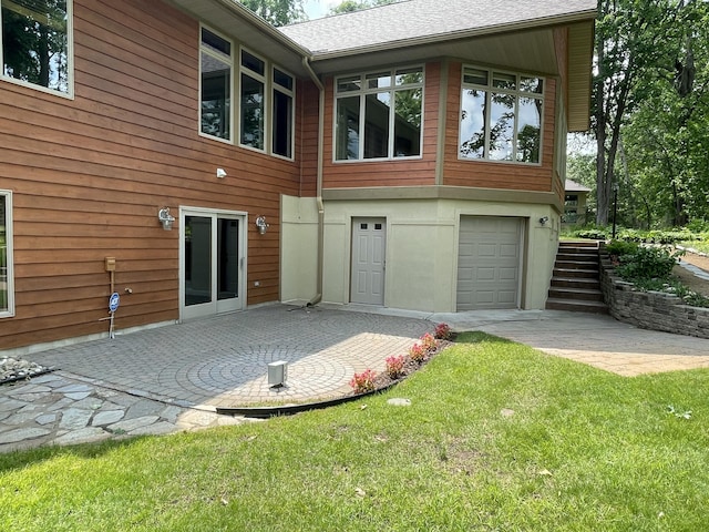 164 Invitational Dr, Gaylord, MI 49735 - back of property featuring a garage, stairs, a yard, and a patio area