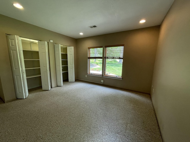 164 Invitational Dr, Gaylord, MI 49735 - unfurnished bedroom featuring multiple closets, light carpet, and recessed lighting