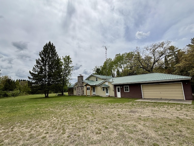 4650 Mckinley Rd, Mio, MI 48647 - view of front of home with a chimney, metal roof, a front lawn, and an attached garage