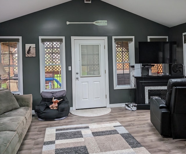 101 Island View Dr, Alpena, MI 49707 - living area with wood finished floors, plenty of natural light, baseboards, and high vaulted ceiling