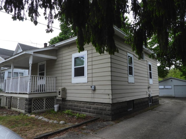 120 Copier St, Cadillac, MI 49601 - view of side of home with a garage, a porch, an outdoor structure, and concrete driveway