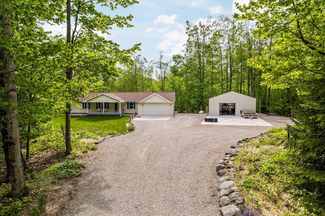 2510 Primrose Rd, Elmira, MI 49730 - view of front of property featuring gravel driveway, covered porch, a garage, and an outdoor structure