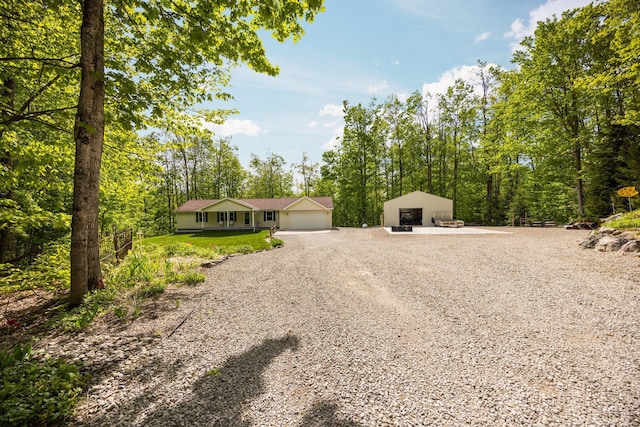 2510 Primrose Rd, Elmira, MI 49730 - view of front of home with a detached garage, an outbuilding, and gravel driveway