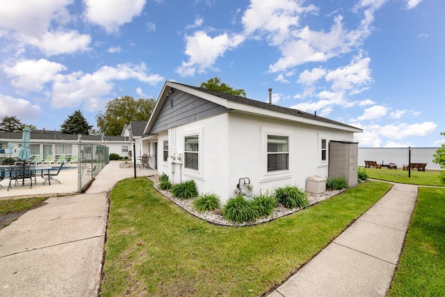 5616 W Houghton Lk, Houghton Lake, MI 48629 - view of side of home with stucco siding and a patio