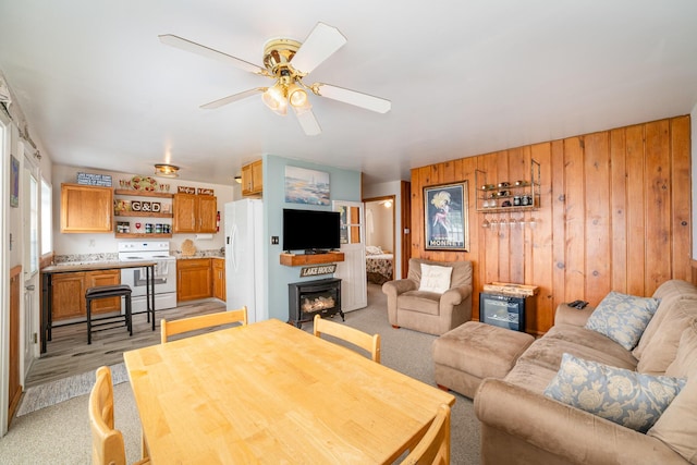 5616 W Houghton Lk, Houghton Lake, MI 48629 - living room with wooden walls, ceiling fan, light colored carpet, and a fireplace