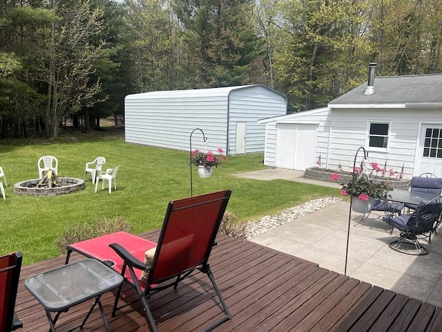 2056 Hobbs Dr, Alpena, MI 49707 - wooden deck with an outdoor fire pit, an outdoor structure, a lawn, and a patio