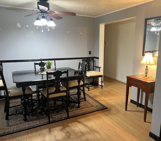 2056 Hobbs Dr, Alpena, MI 49707 - dining space featuring a ceiling fan, light wood-style floors, crown molding, and baseboards