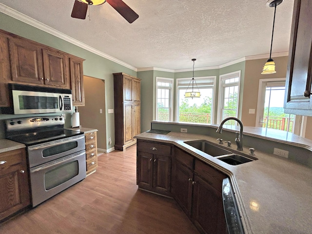 N1746 Smith Rd, Saint Ignace, MI 49781 - kitchen with appliances with stainless steel finishes, light wood-style floors, healthy amount of natural light, a ceiling fan, and a textured ceiling