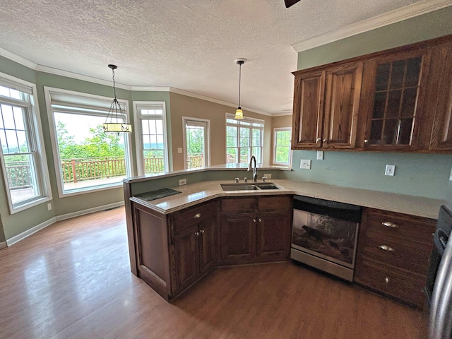 N1746 Smith Rd, Saint Ignace, MI 49781 - kitchen with dishwasher, wood finished floors, light countertops, ornamental molding, and a peninsula