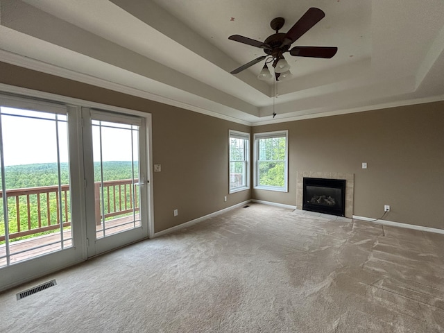 N1746 Smith Rd, Saint Ignace, MI 49781 - unfurnished living room featuring a tray ceiling, carpet floors, ceiling fan, a fireplace, and crown molding