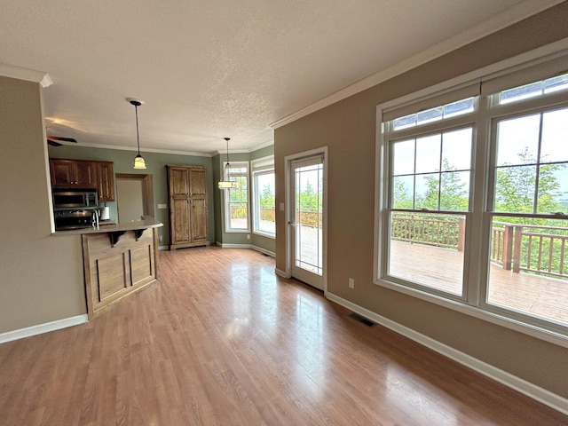 N1746 Smith Rd, Saint Ignace, MI 49781 - unfurnished living room featuring crown molding, light wood-style flooring, and a textured ceiling