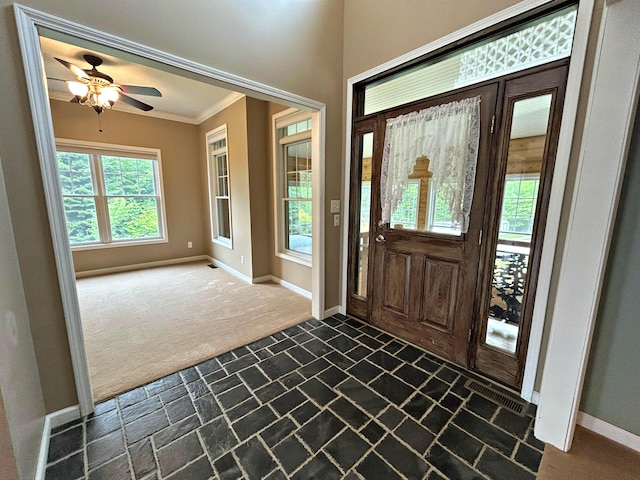 N1746 Smith Rd, Saint Ignace, MI 49781 - foyer entrance featuring ornamental molding, dark carpet, a ceiling fan, and brick patterned flooring