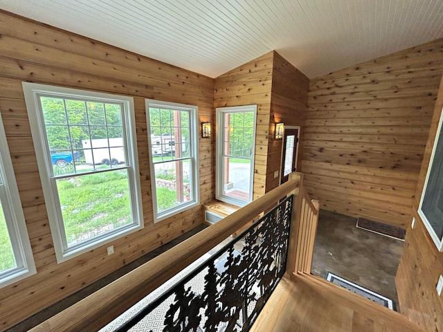 N1746 Smith Rd, Saint Ignace, MI 49781 - hall featuring vaulted ceiling, wood walls, an upstairs landing, and carpet floors
