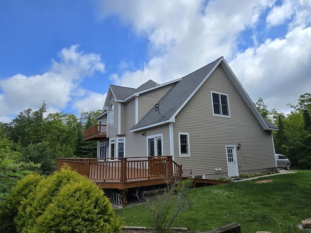 N1746 Smith Rd, Saint Ignace, MI 49781 - rear view of property with a balcony, a lawn, a shingled roof, and a deck