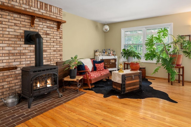 9707 Rogers Rd, Alanson, MI 49706 - living area featuring a wood stove, wood finished floors, and baseboards