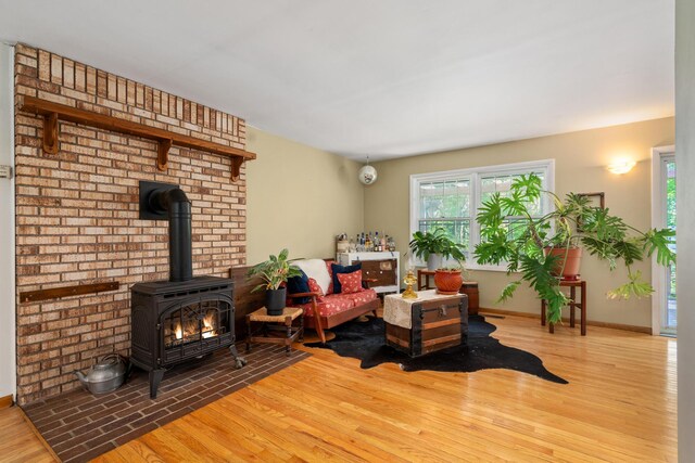 9707 Rogers Rd, Alanson, MI 49706 - living area with wood finished floors, a wood stove, and baseboards