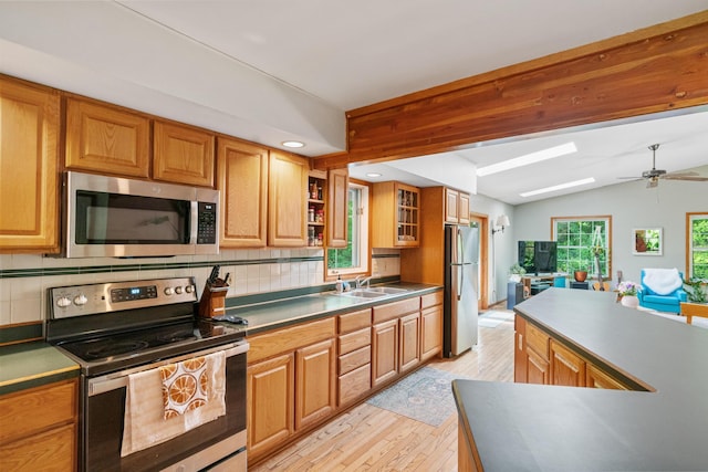 9707 Rogers Rd, Alanson, MI 49706 - kitchen featuring stainless steel appliances, decorative backsplash, light wood-style floors, lofted ceiling, and ceiling fan