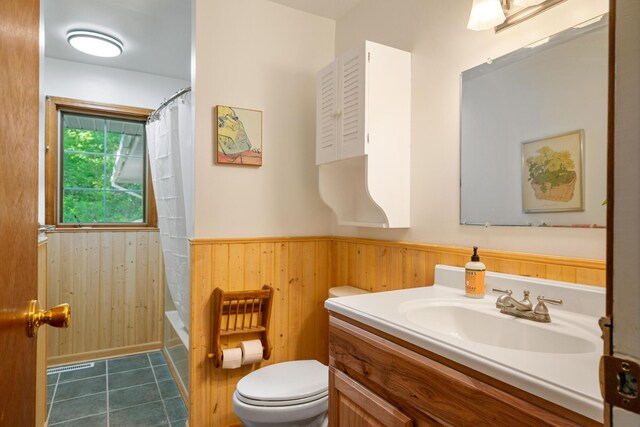 9707 Rogers Rd, Alanson, MI 49706 - bathroom with vanity, toilet, wainscoting, wood walls, and tile patterned floors