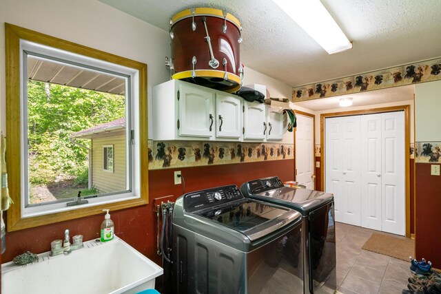 9707 Rogers Rd, Alanson, MI 49706 - laundry area with cabinet space, washing machine and dryer, light tile patterned floors, and a textured ceiling