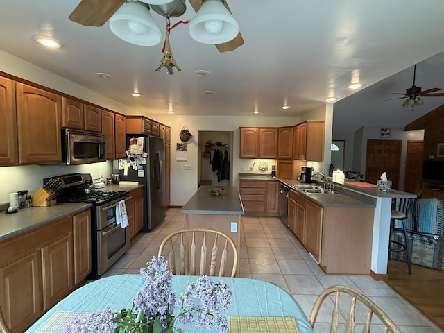 1058 Marlas Way, Cheboygan, MI 49721 - kitchen featuring stainless steel appliances, a ceiling fan, light tile patterned flooring, a kitchen island, and a breakfast bar area