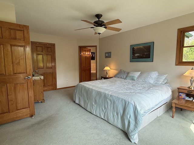 1058 Marlas Way, Cheboygan, MI 49721 - bedroom with light carpet, baseboards, ceiling fan, and connected bathroom