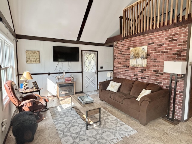 5265 Woodridge Dr, Lewiston, MI 49756 - living area with healthy amount of natural light, high vaulted ceiling, beam ceiling, and a glass covered fireplace