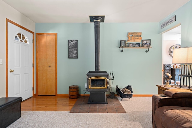 5918 Neumann Rd, Lewiston, MI 49756 - carpeted living area featuring a wood stove and baseboards