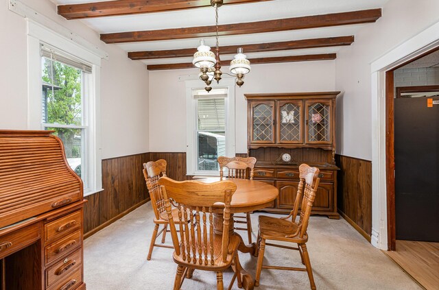 211 S Birney St, Bay City, MI 48708 - dining area with wood walls, a wainscoted wall, a chandelier, beamed ceiling, and light colored carpet