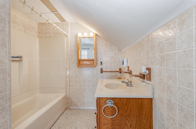 211 S Birney St, Bay City, MI 48708 - bathroom featuring tile walls, shower / bathtub combination, vanity, lofted ceiling, and tile patterned floors