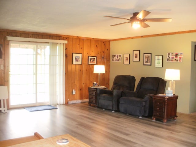 6121 M-33 Hwy, Onaway, MI 49765 - living room featuring a ceiling fan, wood finished floors, and wood walls