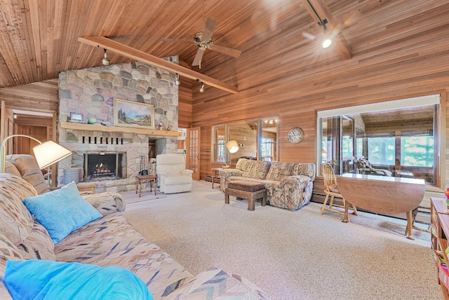 117 Timber Trl, Roscommon, MI 48653 - carpeted living room featuring wooden walls, a wood ceiling with exposed beams, a ceiling fan, a fireplace, and high vaulted ceiling
