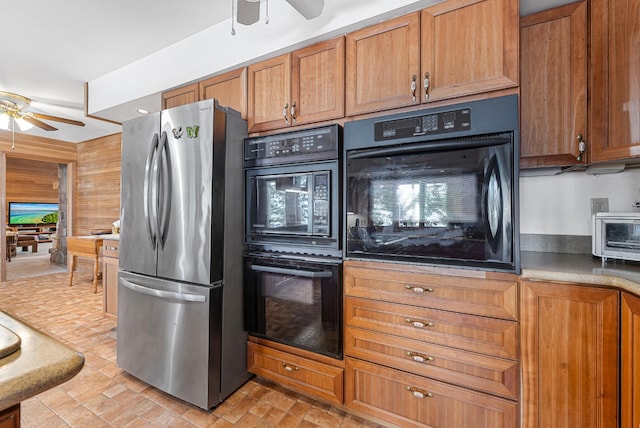 117 Timber Trl, Roscommon, MI 48653 - kitchen featuring freestanding refrigerator, ceiling fan, brown cabinets, and wood walls