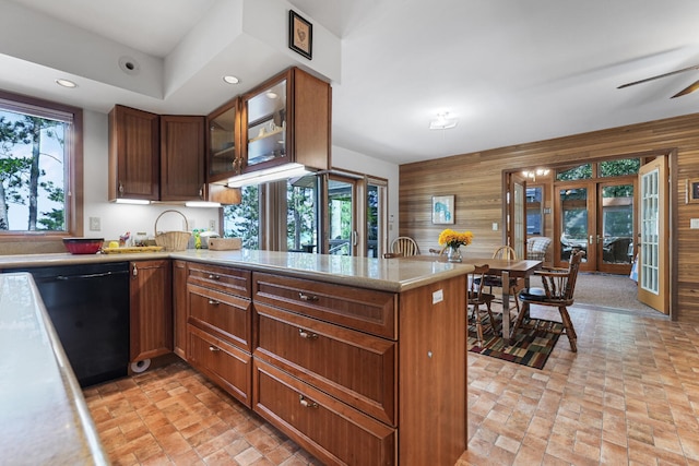 117 Timber Trl, Roscommon, MI 48653 - kitchen with french doors, wooden walls, dishwasher, light countertops, and a peninsula
