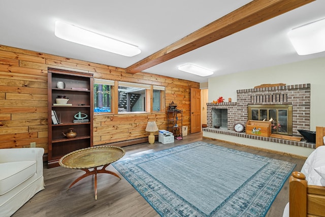 117 Timber Trl, Roscommon, MI 48653 - living area with a brick fireplace, wood walls, beam ceiling, wood finished floors, and a baseboard heating unit