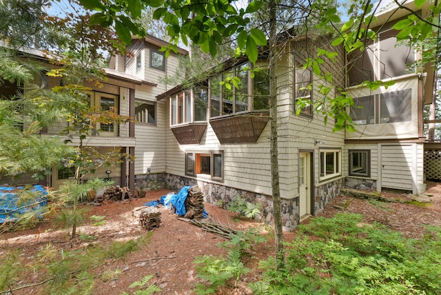 117 Timber Trl, Roscommon, MI 48653 - rear view of house featuring a sunroom and stone siding