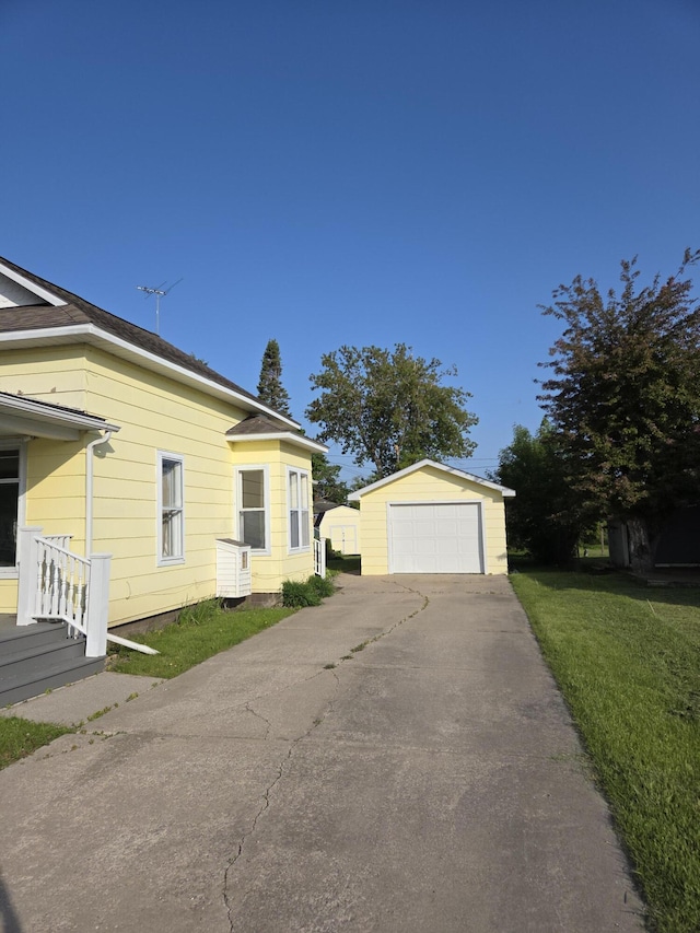 208 S S D St, Cheboygan, MI 49721 - view of property exterior with an outbuilding, asphalt driveway, and a garage
