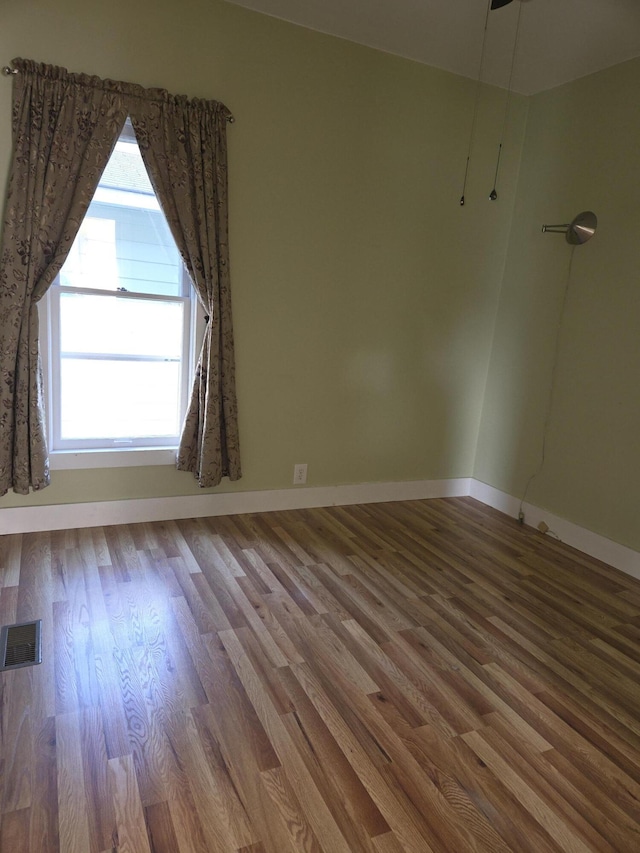 208 S S D St, Cheboygan, MI 49721 - empty room featuring wood finished floors and baseboards