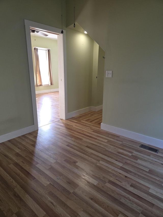 208 S S D St, Cheboygan, MI 49721 - unfurnished room with wood finished floors, baseboards, a ceiling fan, and vaulted ceiling