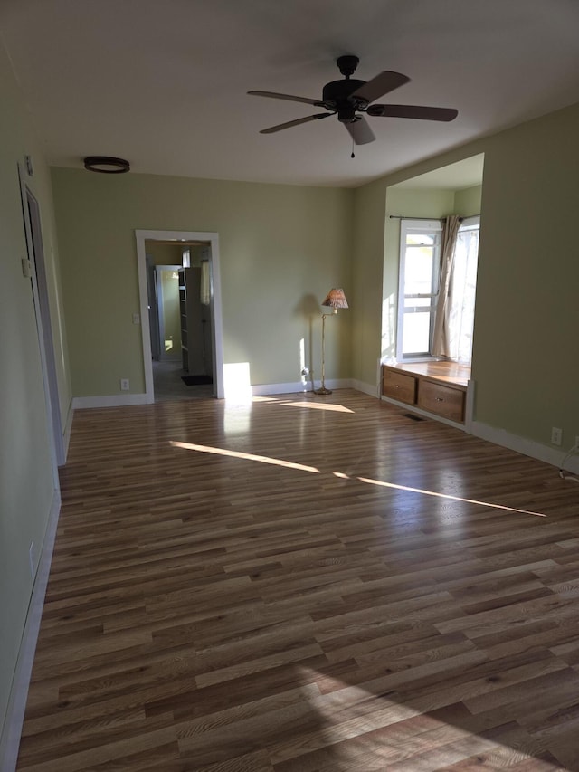 208 S S D St, Cheboygan, MI 49721 - empty room with wood finished floors, ceiling fan, and baseboards